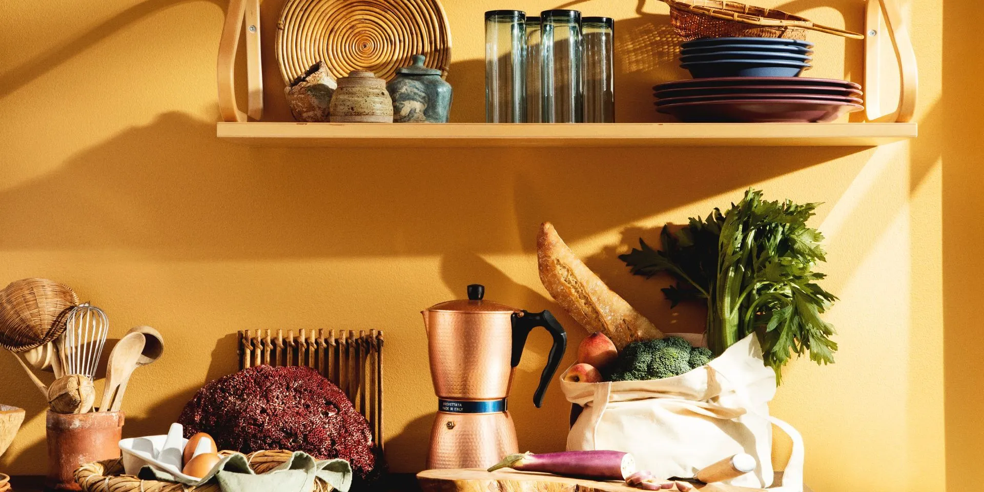 ściana w jasnym, żółtym odcieniu z blatem kuchennym i półką