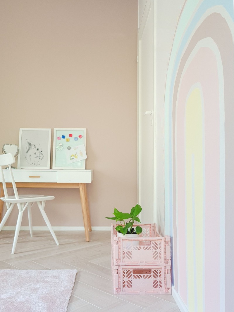 pokój dziecięcy w beżowych kolorach i ze wzorem pastelowej tęczy na ścianie
